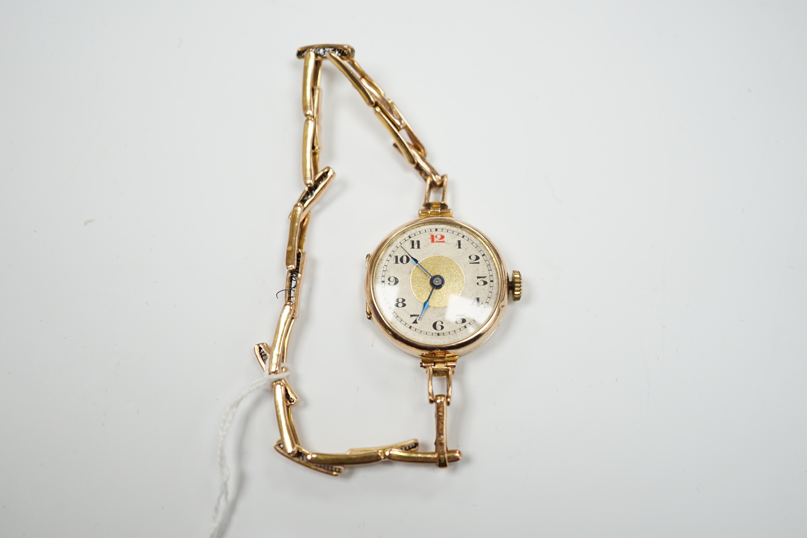 An early 20th century 9ct gold manual wind wrist watch, on a 9ct expanding bracelet, case diameter 25mm, gross weight 14.9 grams.